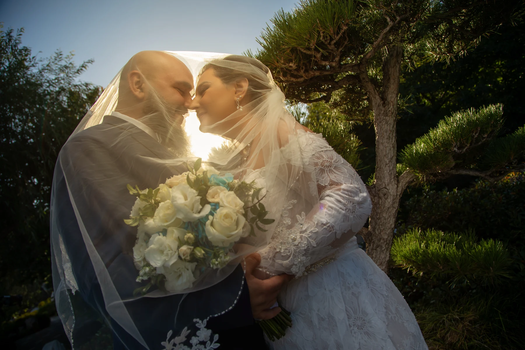 A Los Angeles bride and groom handing a small thank-you gift to their wedding photographer at a sunset reception