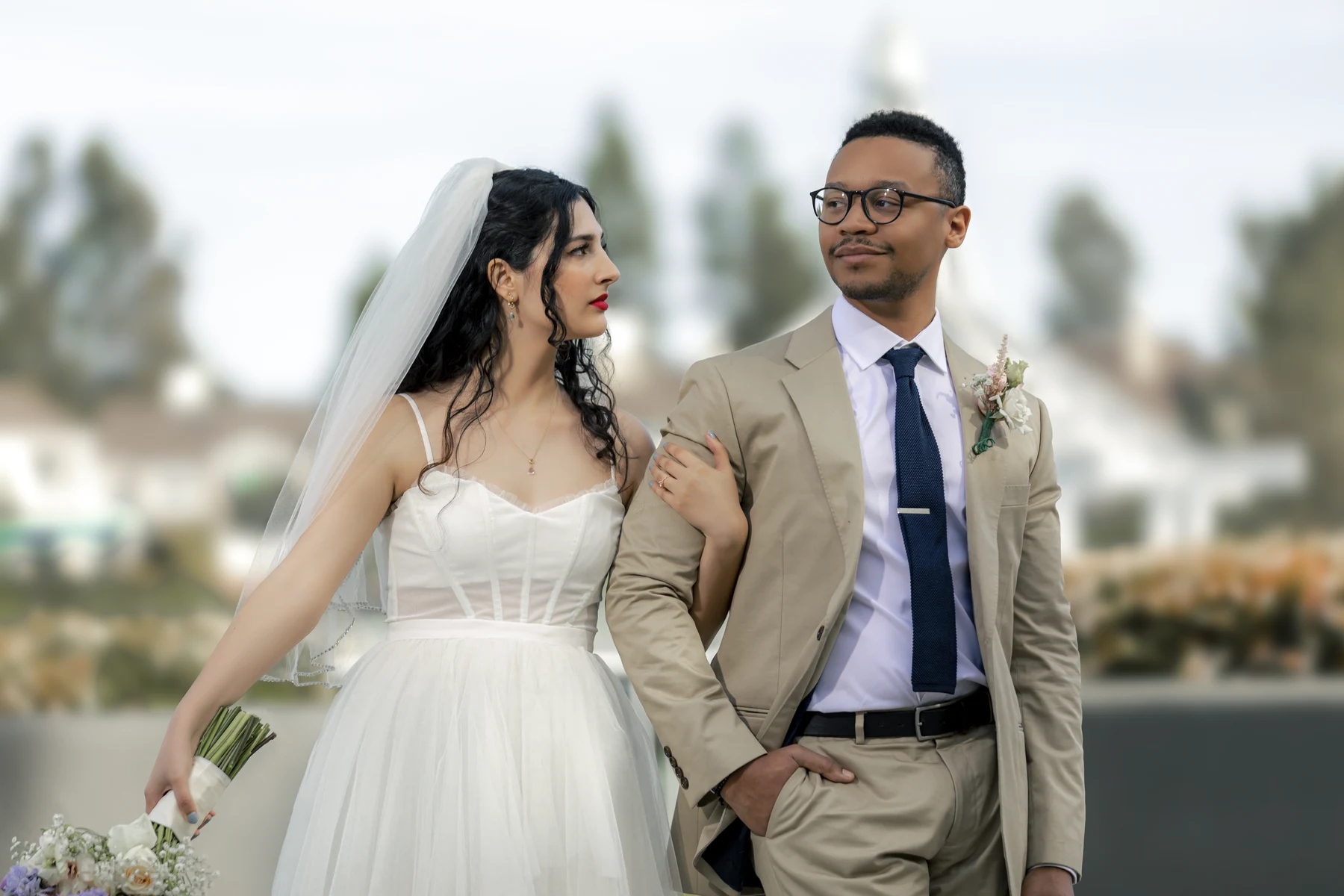 A destination wedding photographer capturing a couple at golden hour on a coastal cliff overlooking the ocean