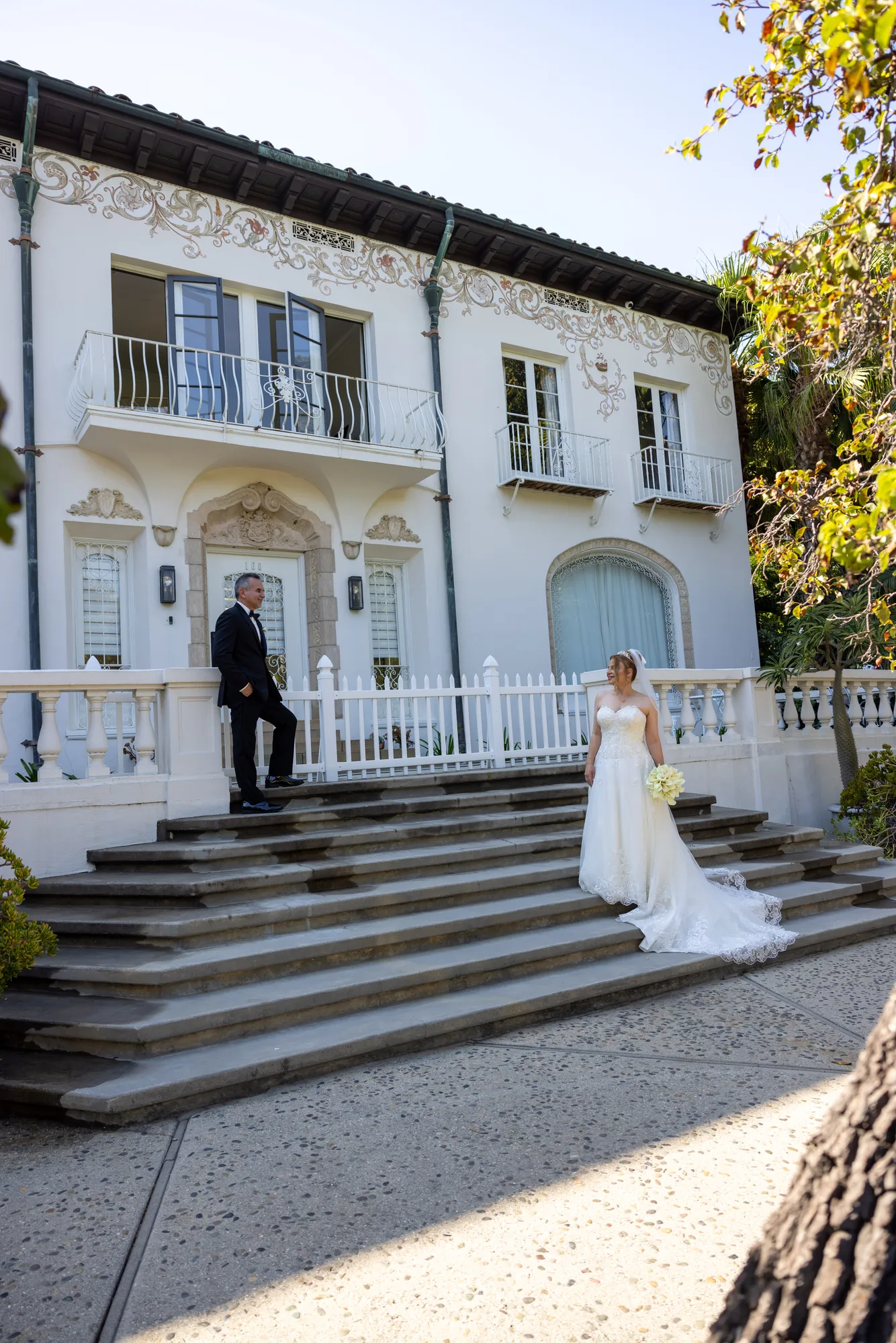 Couple on the balustraded steps of the white mansion at Ambassador Gardens, Pasadena