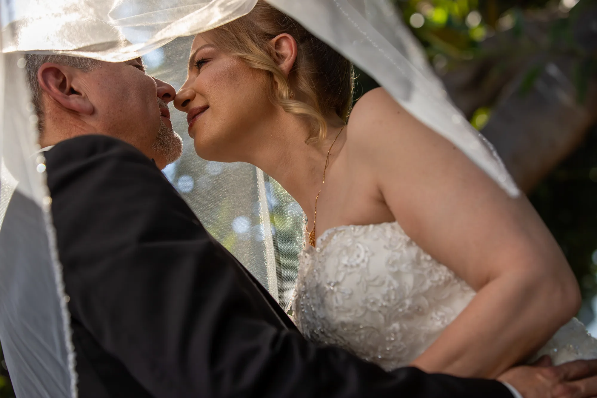 Veil portrait of the couple beneath the trees at Ambassador Mansion & Gardens, Pasadena