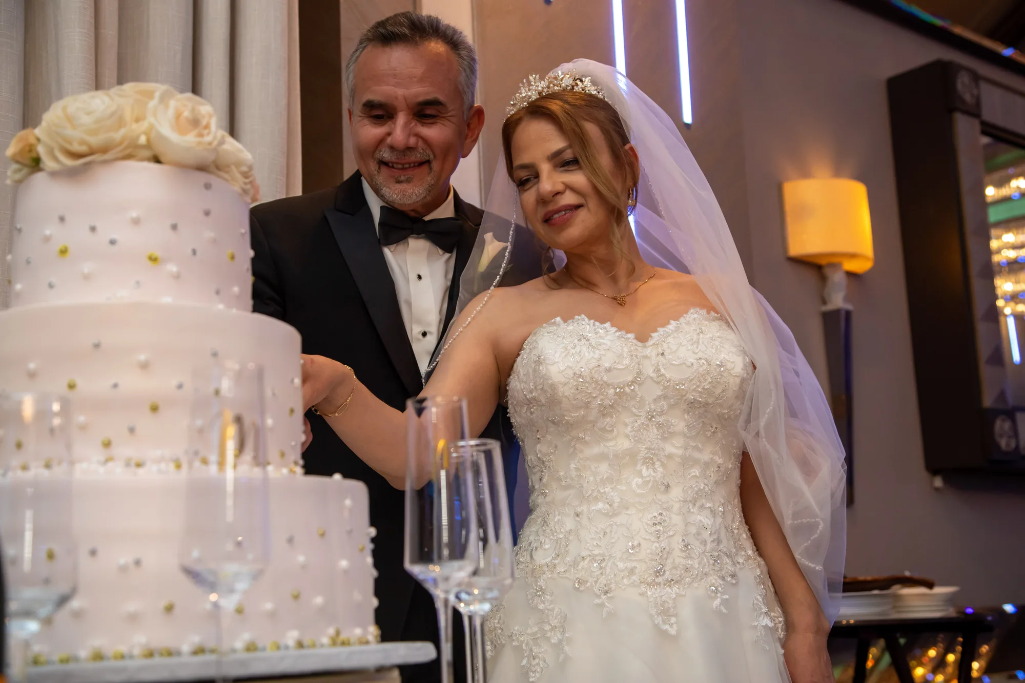 Couple cutting the cake during their reception at De Luxe Banquet Hall, Burbank