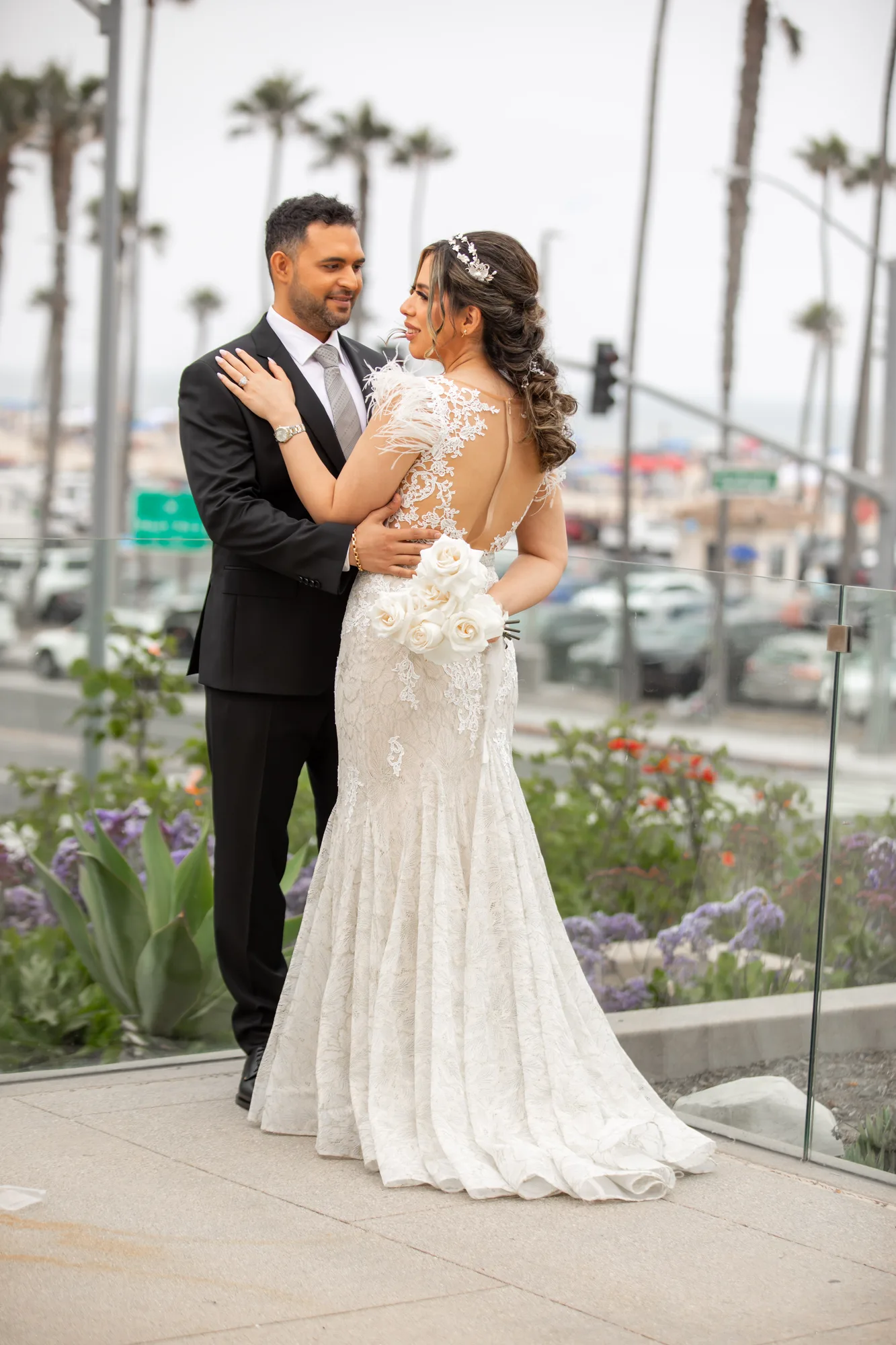 Bride and groom on a palm-lined walkway above Pacific Coast Highway at Paséa Hotel & Spa