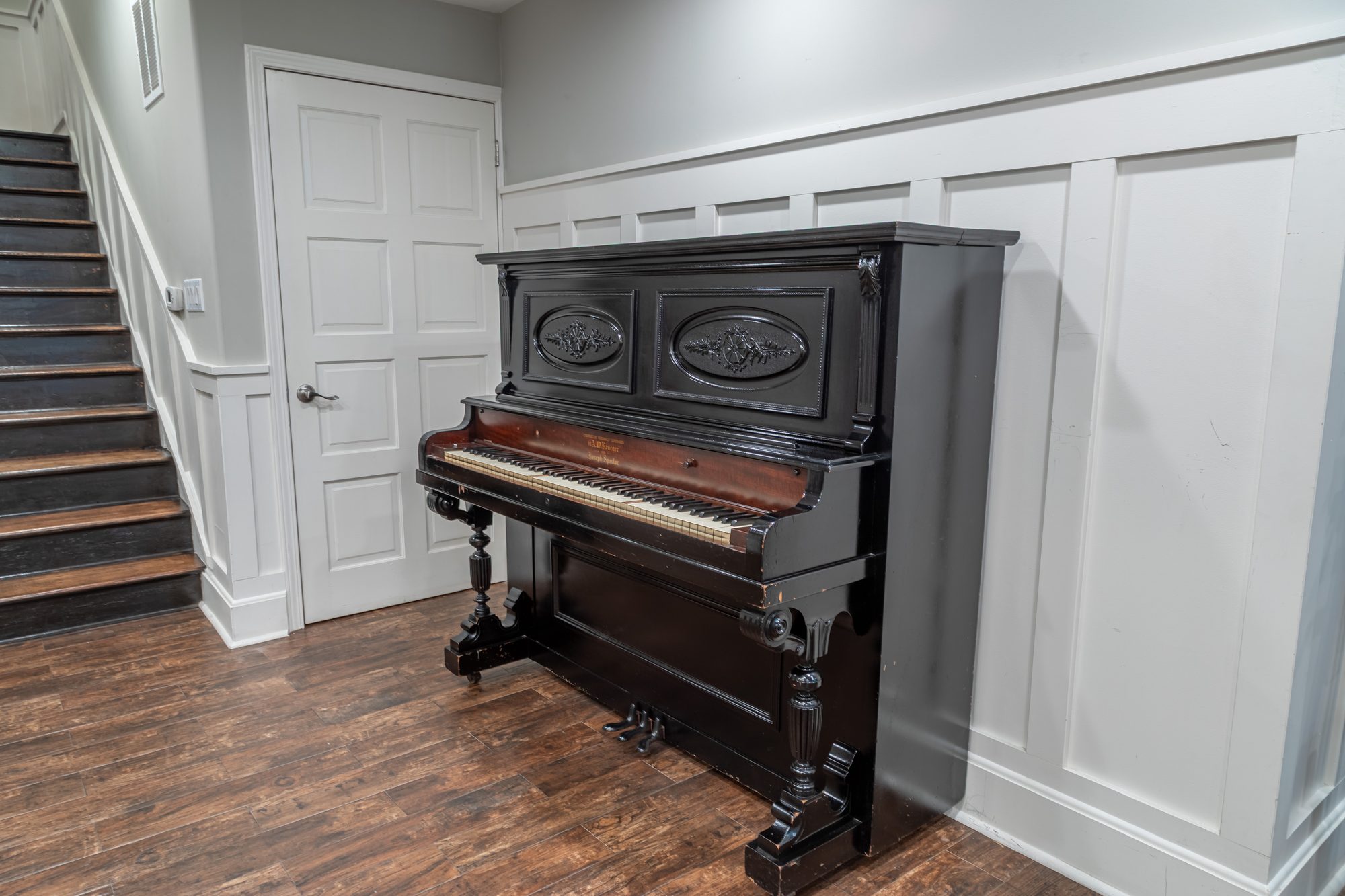 The upright piano against the panelling at Lombardi House