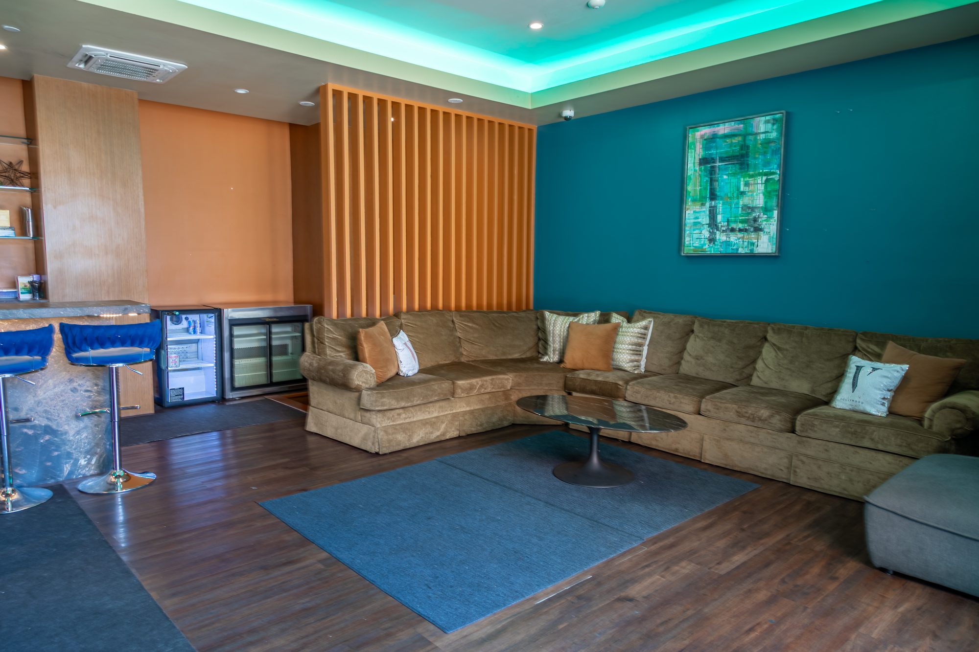 A green room lounge at The Vermont Hollywood, teal walls and deep sofas